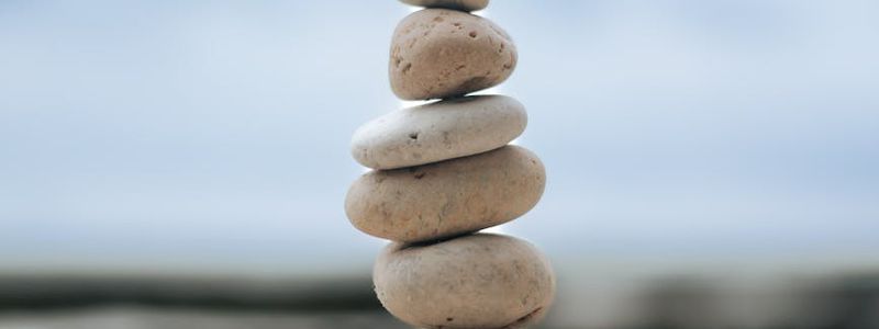 A balanced stack of smooth stones on a wooden surface.