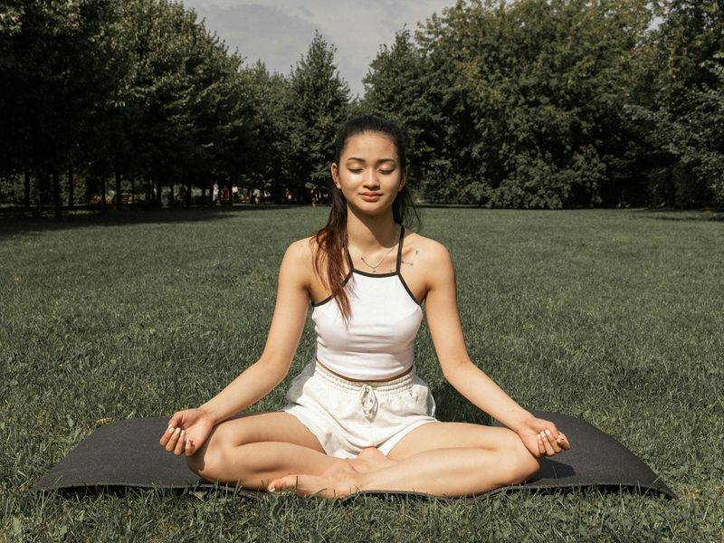 Woman meditating in a serene, nature-inspired setting.